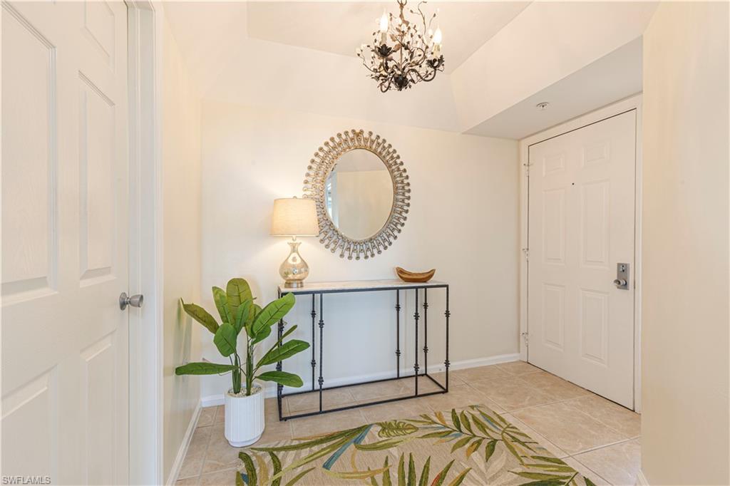 25 Bluebill Avenue, Unit 301 Naples, FL 34108 - Photo 2 of 41 a view of a bedroom with a table and a chair