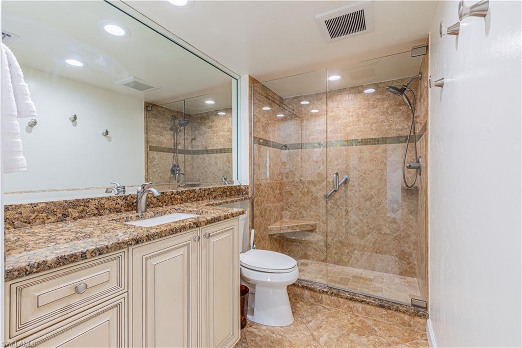 25 Bluebill Avenue, Unit 301 Naples, FL 34108 - Photo 25 of 41 a bathroom with a granite countertop sink a toilet and shower