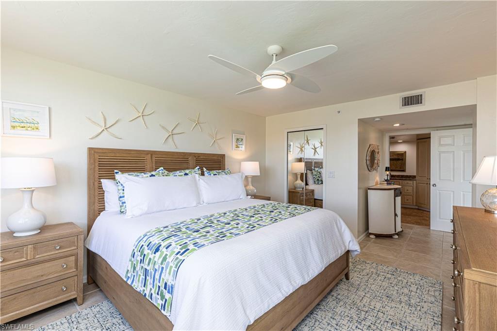 25 Bluebill Avenue, Unit 301 Naples, FL 34108 - Photo 27 of 41 a bedroom with a bed and a chandelier