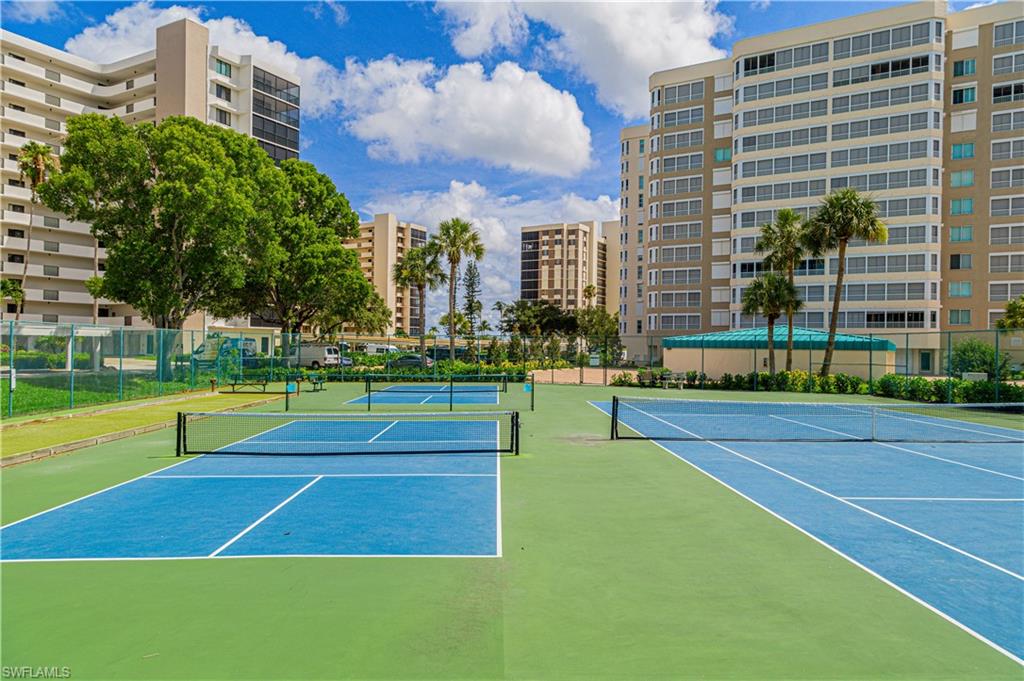 25 Bluebill Avenue, Unit 301 Naples, FL 34108 - Photo 35 of 41 a tennis court with view of buildings in the background