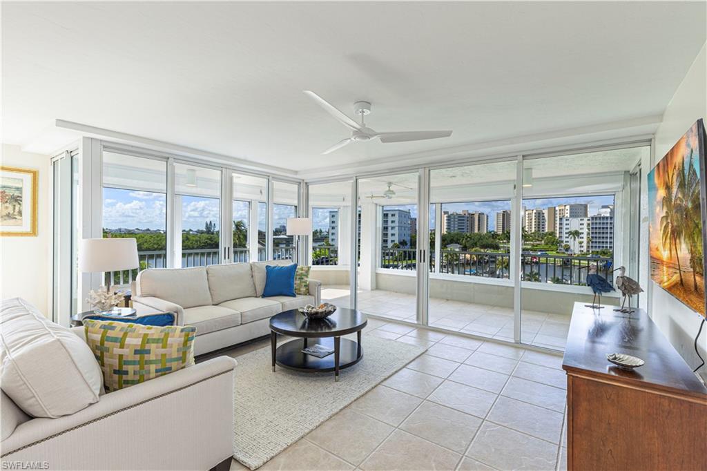 25 Bluebill Avenue, Unit 301 Naples, FL 34108 - Photo 5 of 41 a living room with furniture and a floor to ceiling window