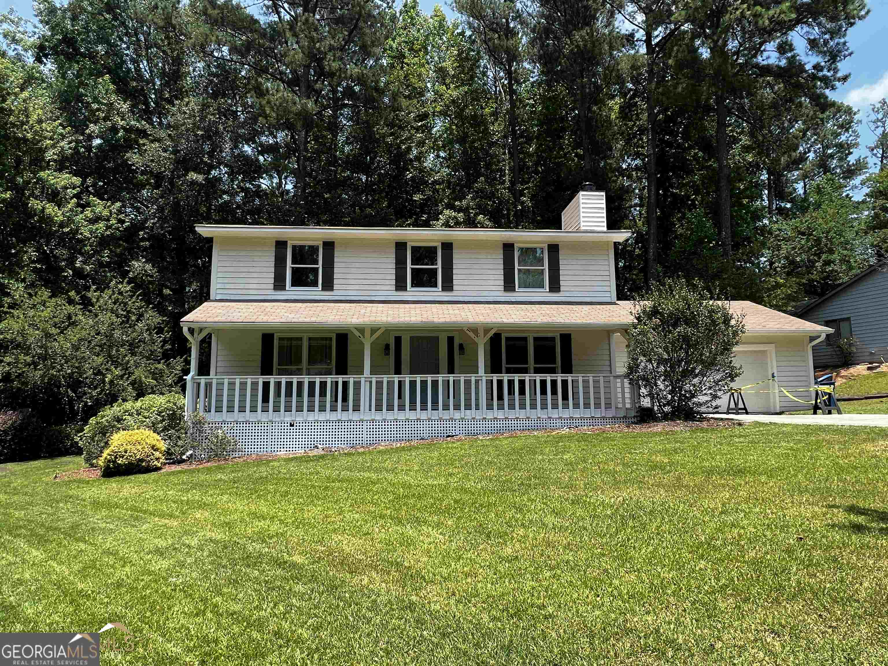 a view of a house with a yard and sitting area