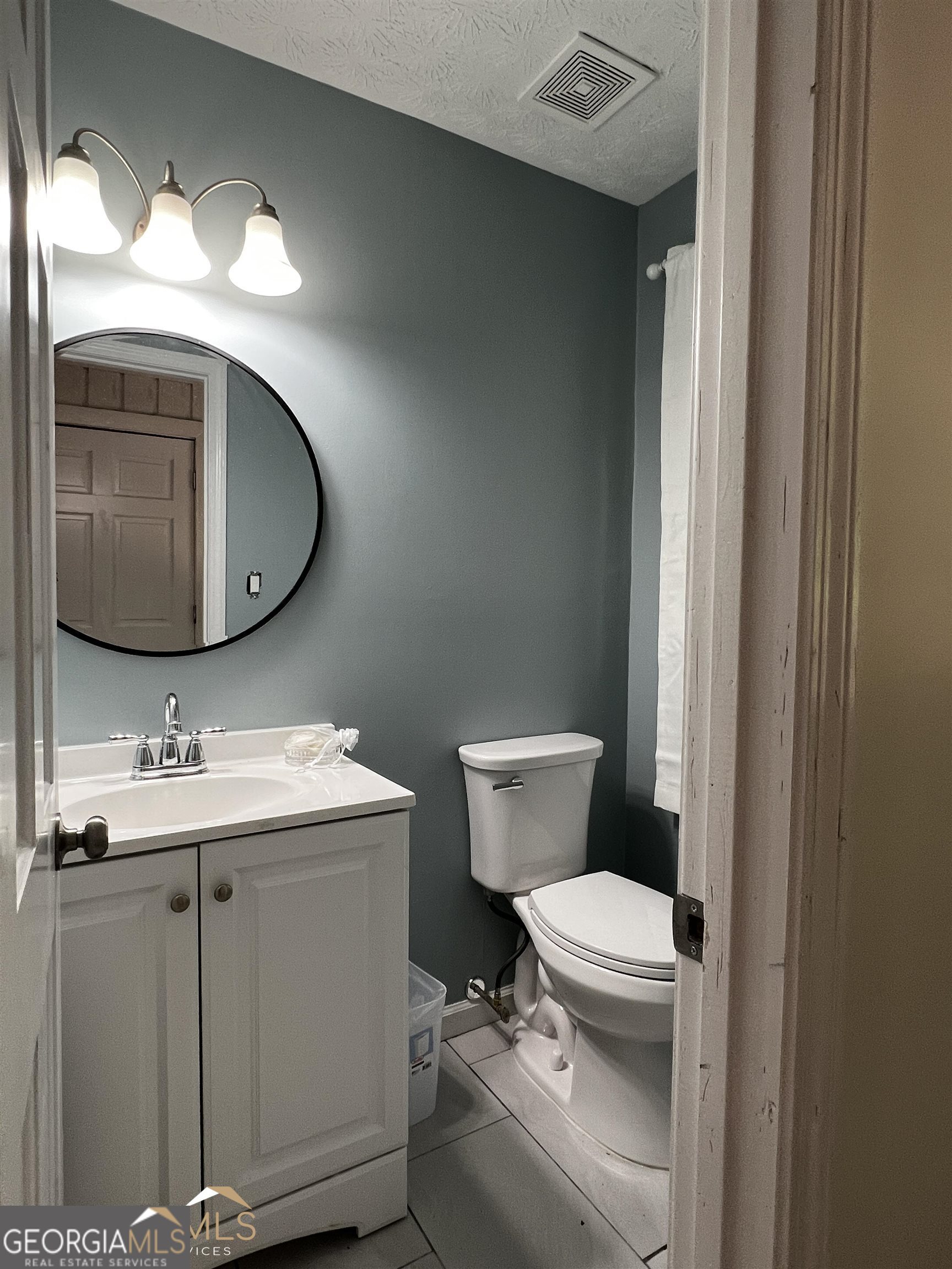 208 Swanson Ridge Peachtree City, GA 30269 - Photo 34 of 40 a bathroom with a toilet a sink and mirror