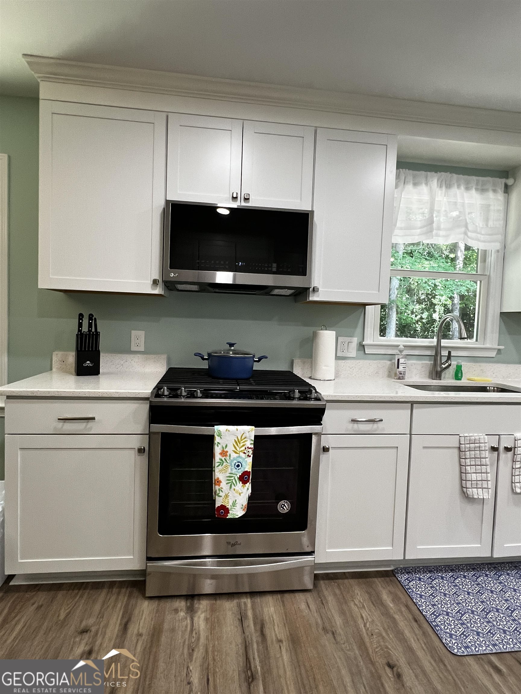 208 Swanson Ridge Peachtree City, GA 30269 - Photo 8 of 40 a kitchen with stainless steel appliances a stove a sink and a microwave