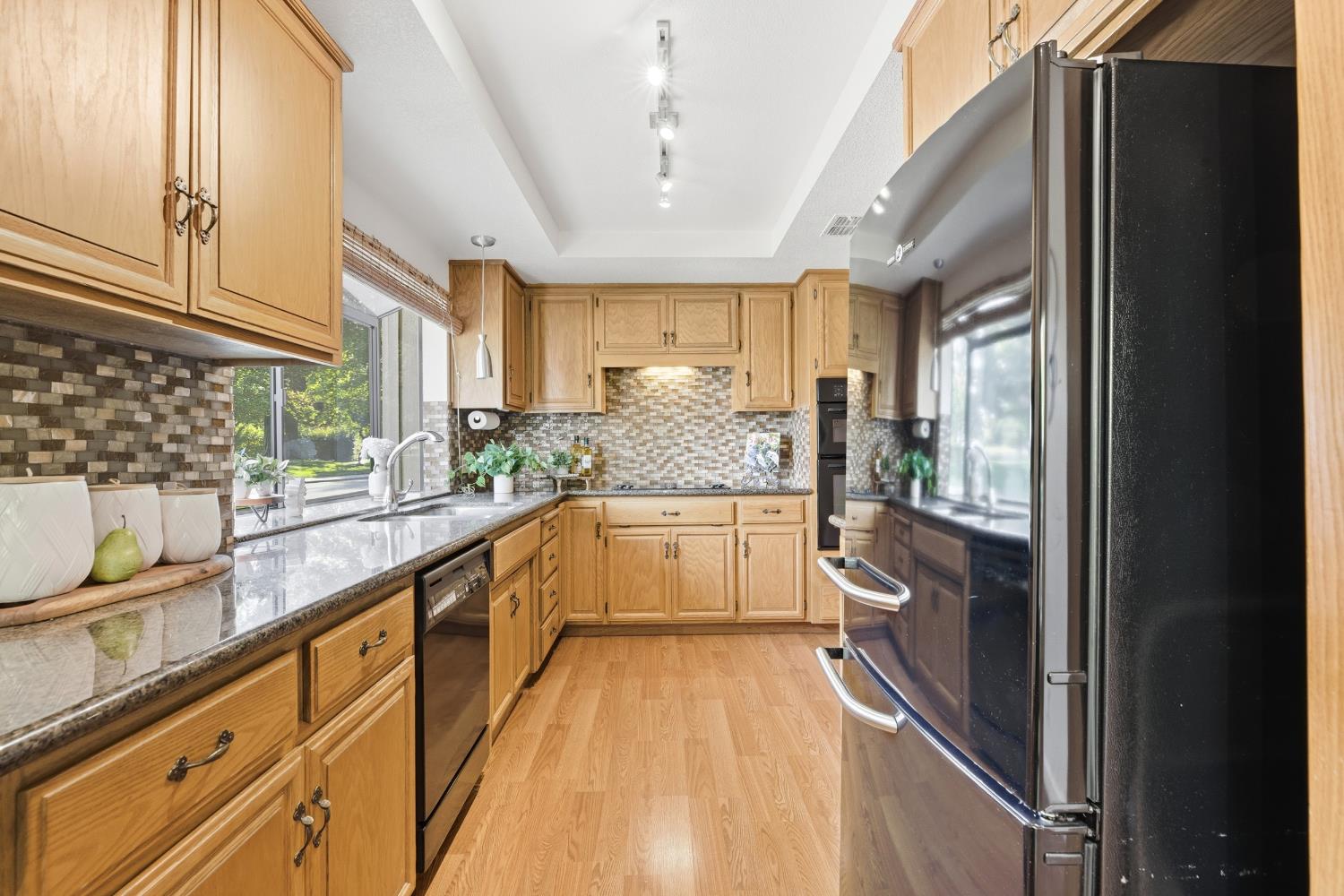 1833 Edgebrook Drive, Unit A Modesto, CA 95354 - Photo 17 of 43 a large white kitchen with kitchen island granite countertop a large window and stainless steel appliances