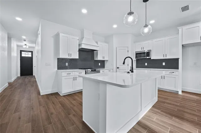a kitchen with kitchen island white cabinets and refrigerator