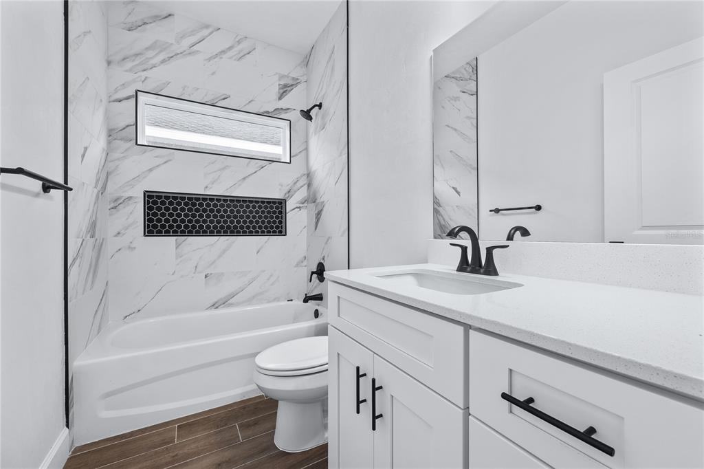 6682 Southwest 10th Lane Gainesville, FL 32607 - Photo 7 of 28 a bathroom with a granite countertop sink toilet and shower