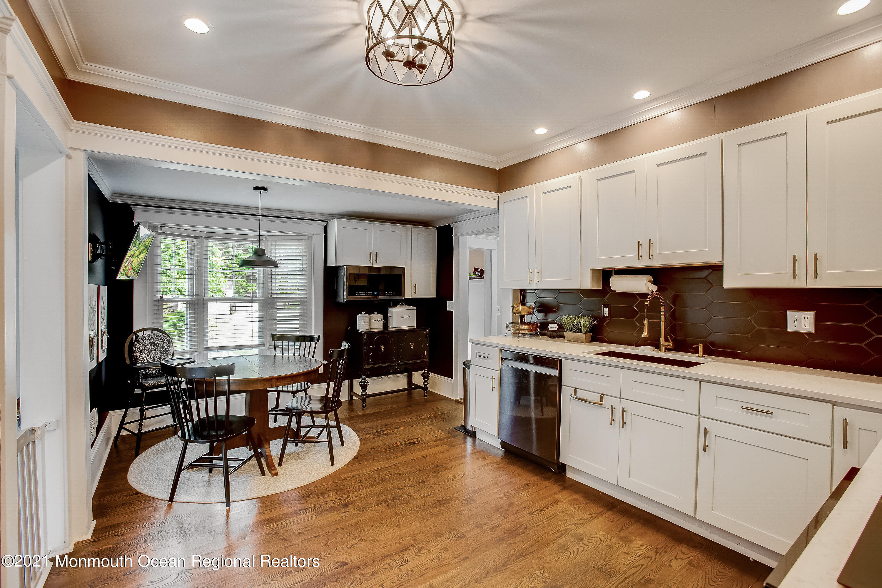 107 Brown Road Howell, NJ 07731 - Photo 6 of 43 a kitchen with stainless steel appliances kitchen island granite countertop a stove a sink a dining table and chairs with wooden floor