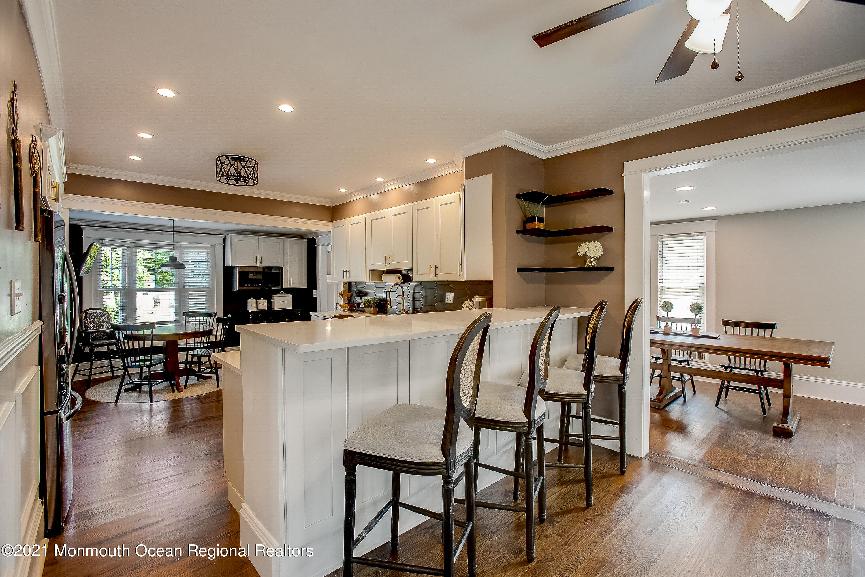 107 Brown Road Howell, NJ 07731 - Photo 9 of 43 a kitchen with stainless steel appliances kitchen island granite countertop a refrigerator a stove a dining table and chairs with wooden floor