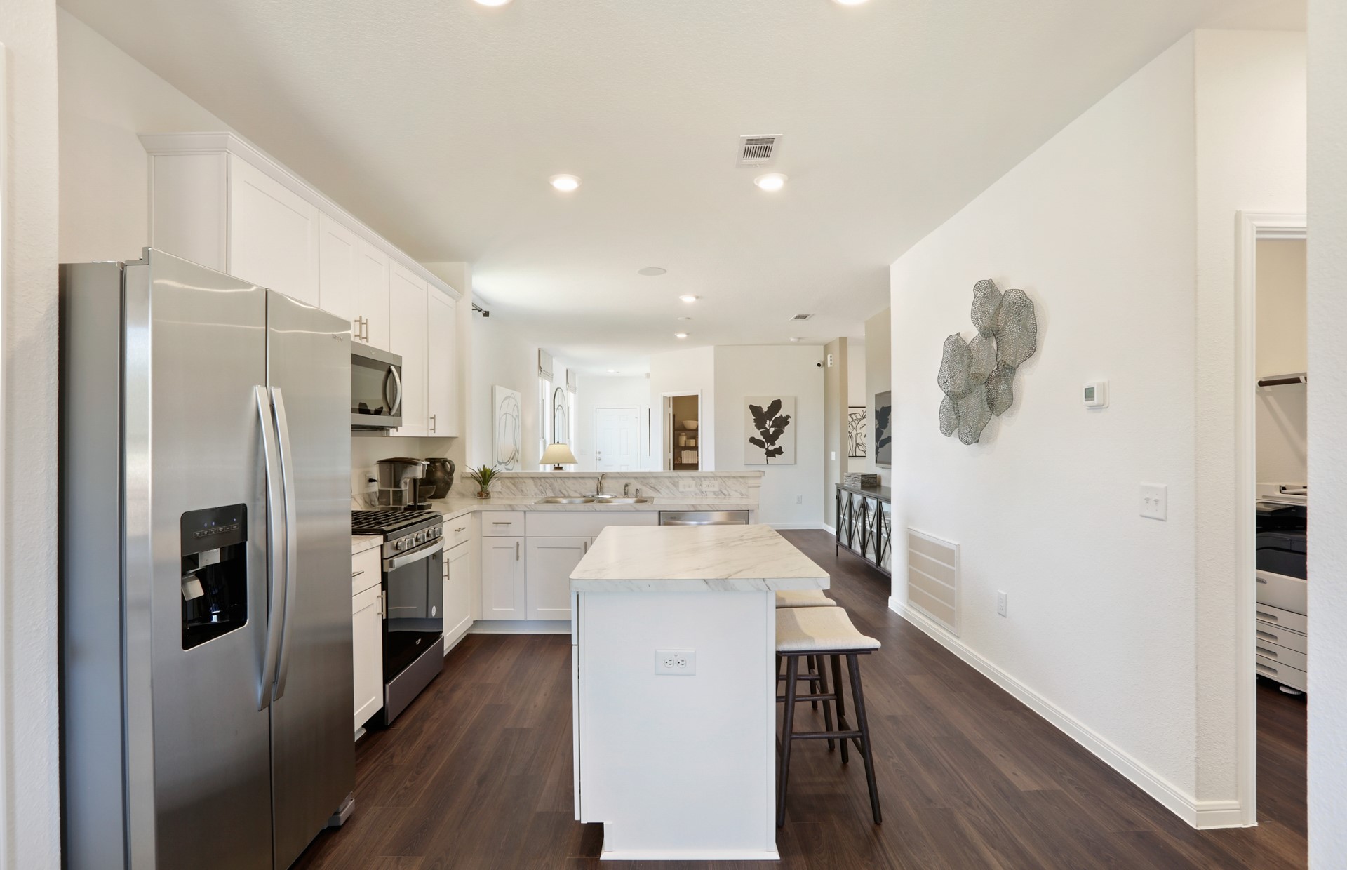 16145 Sepia Manor Street Conroe, TX 77302 - Photo 15 of 36 a white kitchen with wooden floor and stainless steel appliances