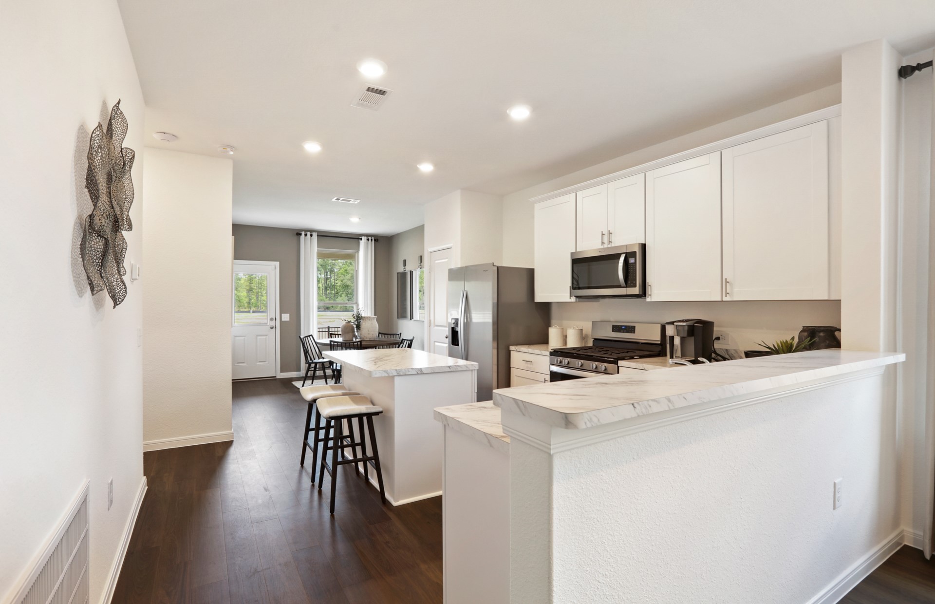 16145 Sepia Manor Street Conroe, TX 77302 - Photo 10 of 36 a kitchen with stainless steel appliances a stove a sink a refrigerator white cabinets and wooden floor