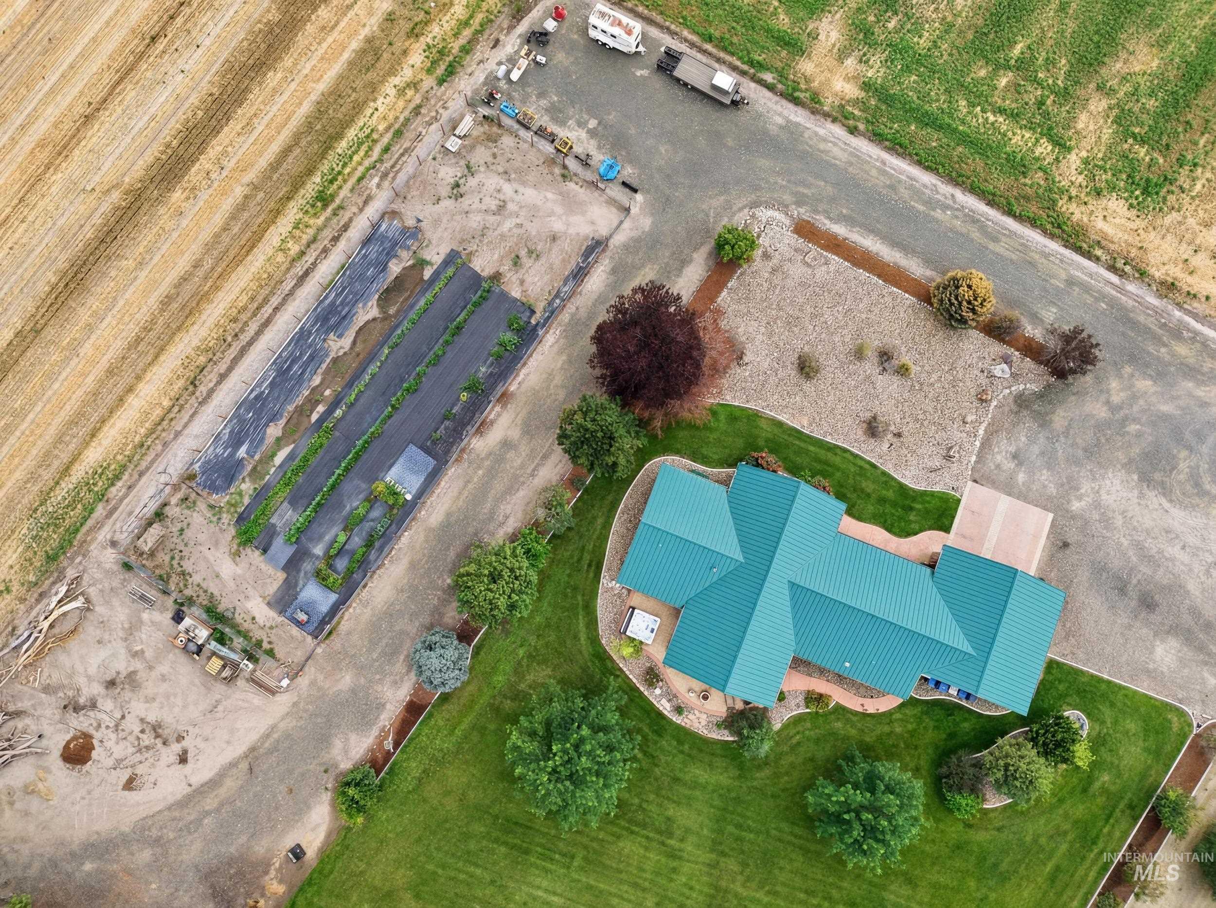 339 Airport Road Weiser, ID 83672 - Photo 42 of 49 Property featuring a distinct teal-colored roof, manicured green lawns, and a gravel driveway