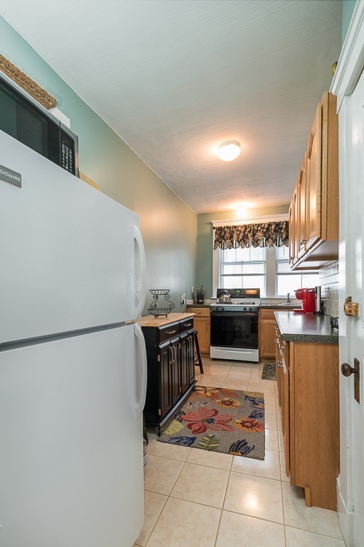 21 Thorndike Street, Unit 4 Beverly, MA 01915 - Photo 11 of 20 a kitchen with stainless steel appliances a refrigerator and a stove top oven
