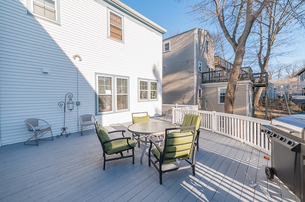 21 Thorndike Street, Unit 4 Beverly, MA 01915 - Photo 16 of 20 a view of a deck with table and chairs and wooden floor