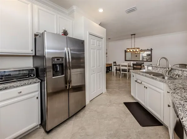 a kitchen with granite countertop a refrigerator stove and sink
