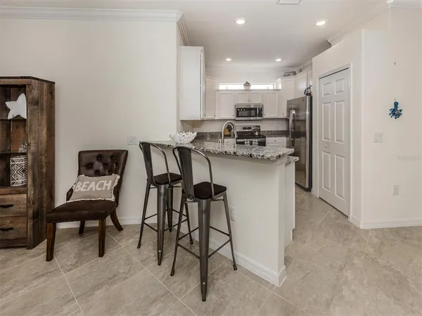 a kitchen with refrigerator and chairs