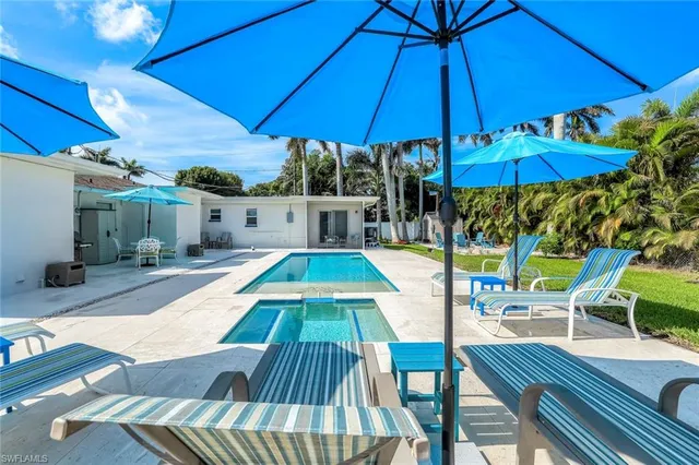 a view of a chair and tables in the patio with a backyard