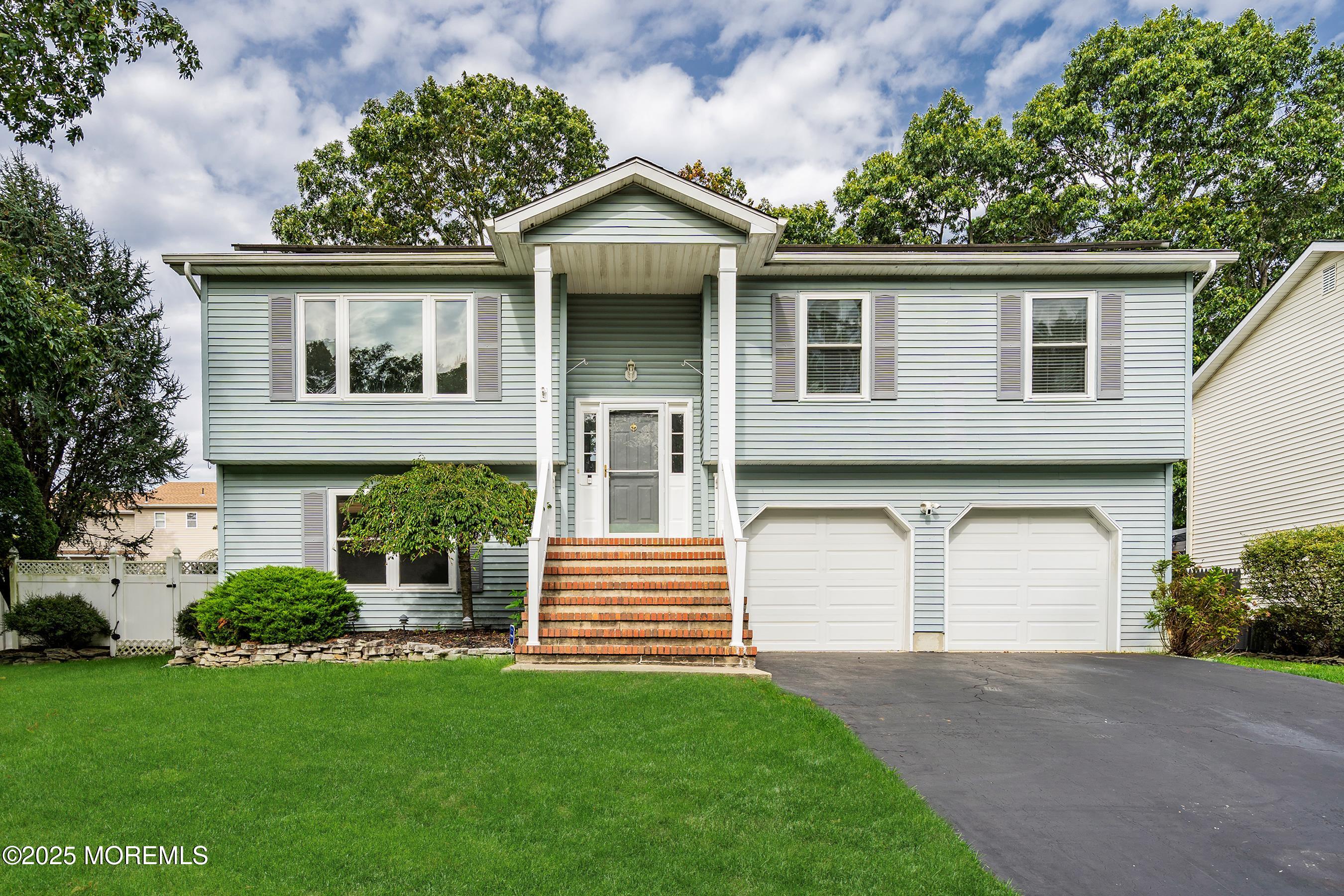 122 Moses Milch Drive Howell, NJ 07731 - Photo 1 of 15 a front view of a house with a garden