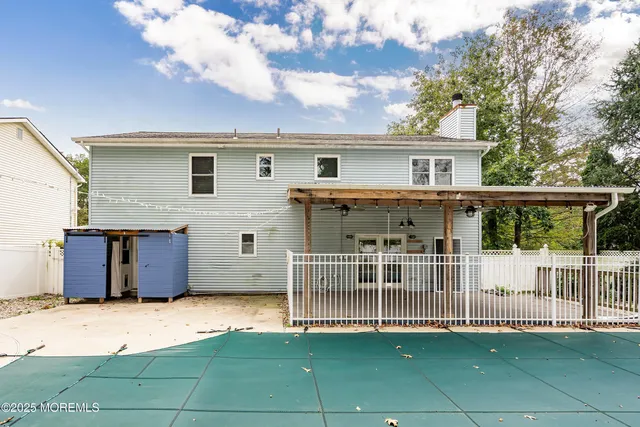 a view of a house with a backyard and a large tree