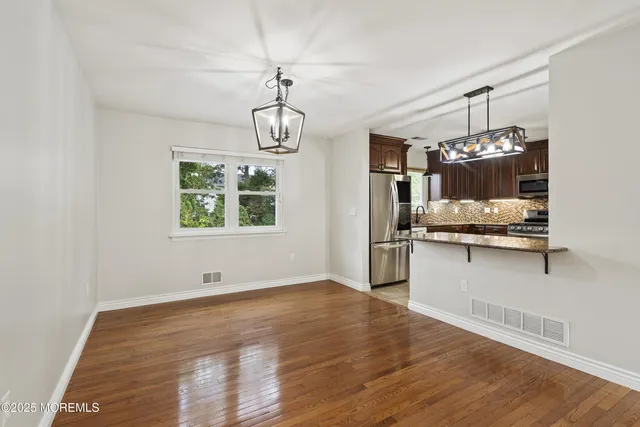 a kitchen with kitchen island granite countertop a oven and refrigerator