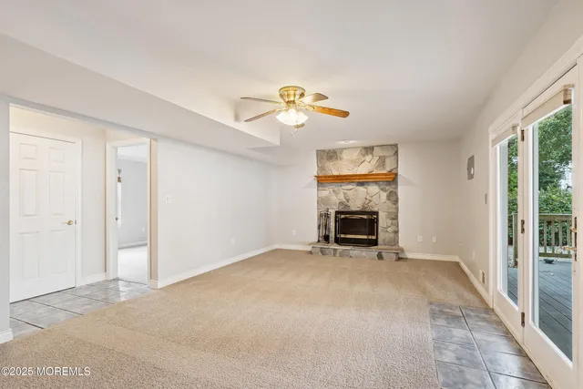a view of an empty room with a fireplace and a window