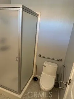 a white toilet sitting next to a shower