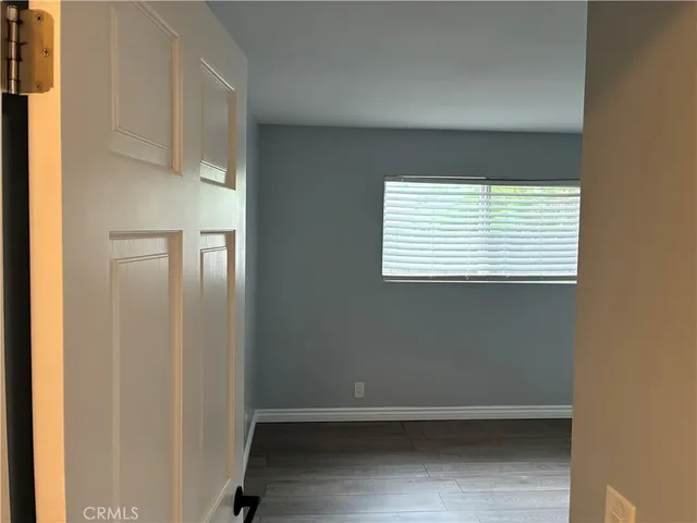 an empty room with wooden floor and closet area