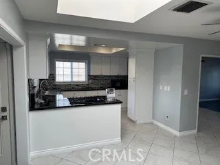 a kitchen with granite countertop a sink a stove and cabinets