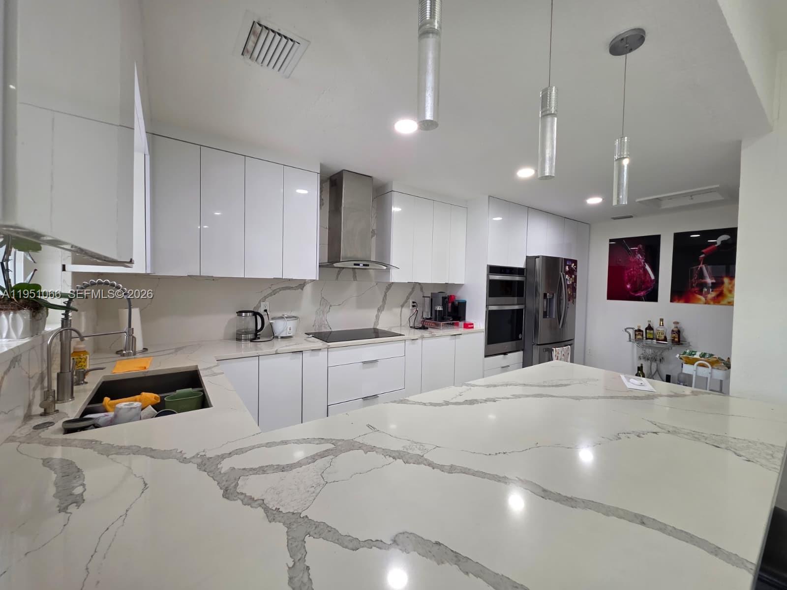 13370 Southwest 261st Terrace Homestead, FL 33032 - Photo 11 of 35 a kitchen with stainless steel appliances kitchen island granite countertop a sink and cabinets