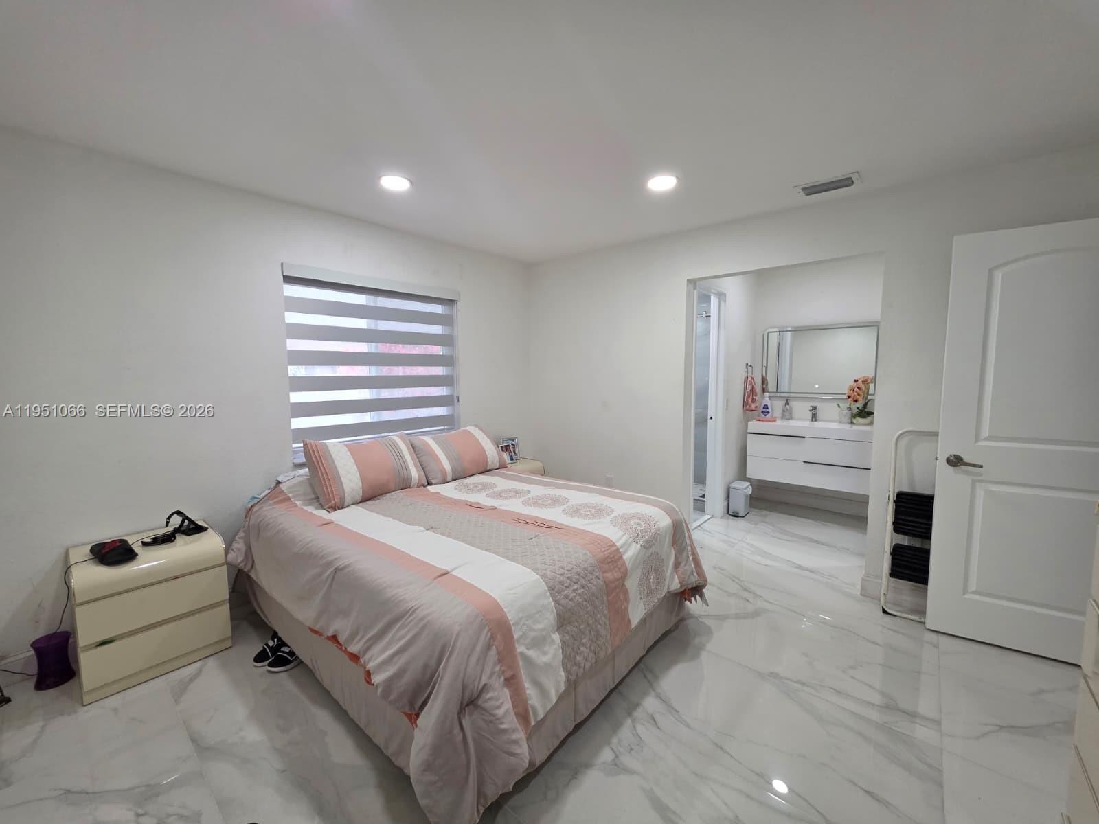 13370 Southwest 261st Terrace Homestead, FL 33032 - Photo 15 of 35 a bedroom with a bed and a refrigerator