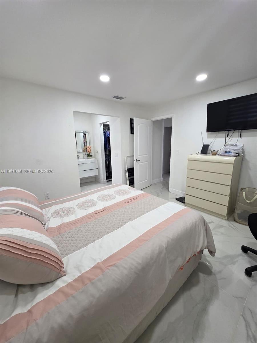 13370 Southwest 261st Terrace Homestead, FL 33032 - Photo 19 of 35 a bedroom with a bed and a flat screen tv