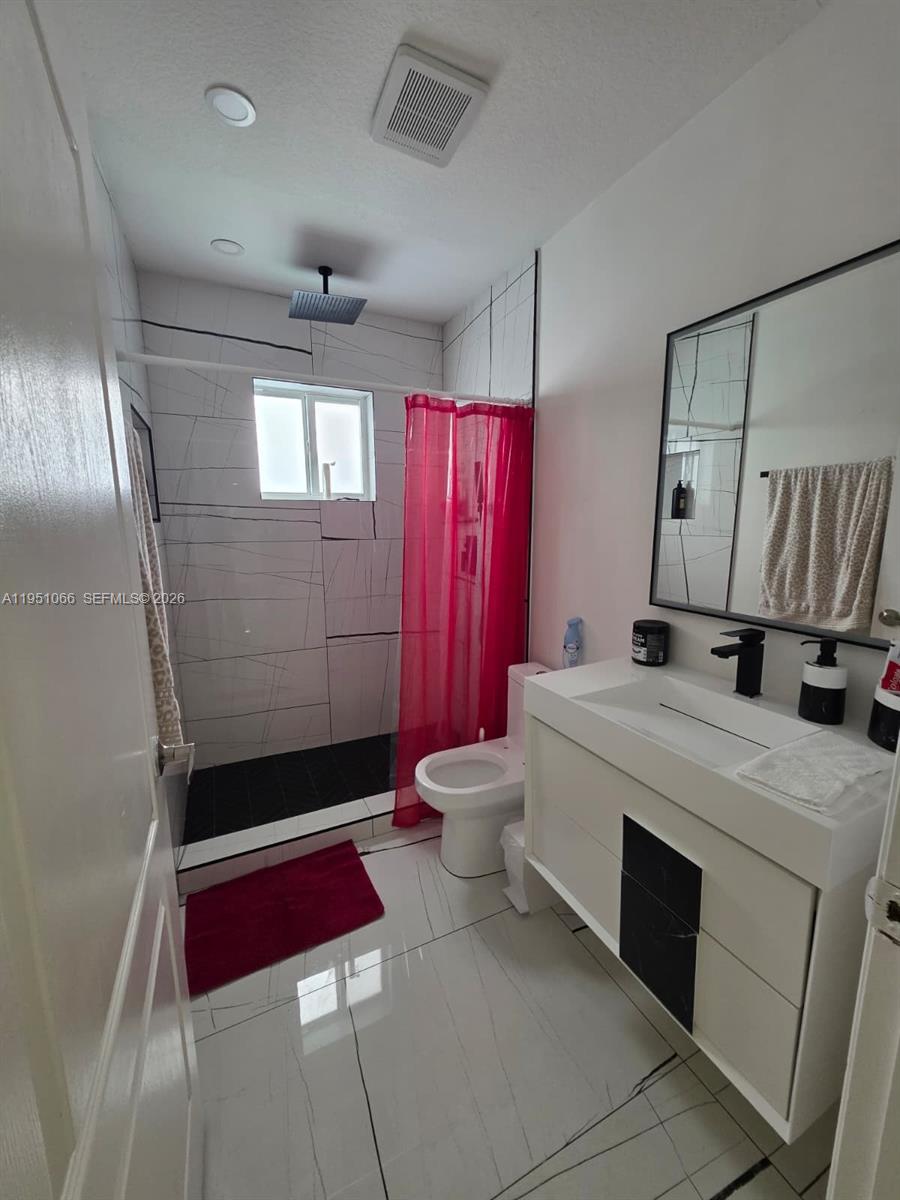 13370 Southwest 261st Terrace Homestead, FL 33032 - Photo 23 of 35 a bathroom with a sink a toilet and mirror