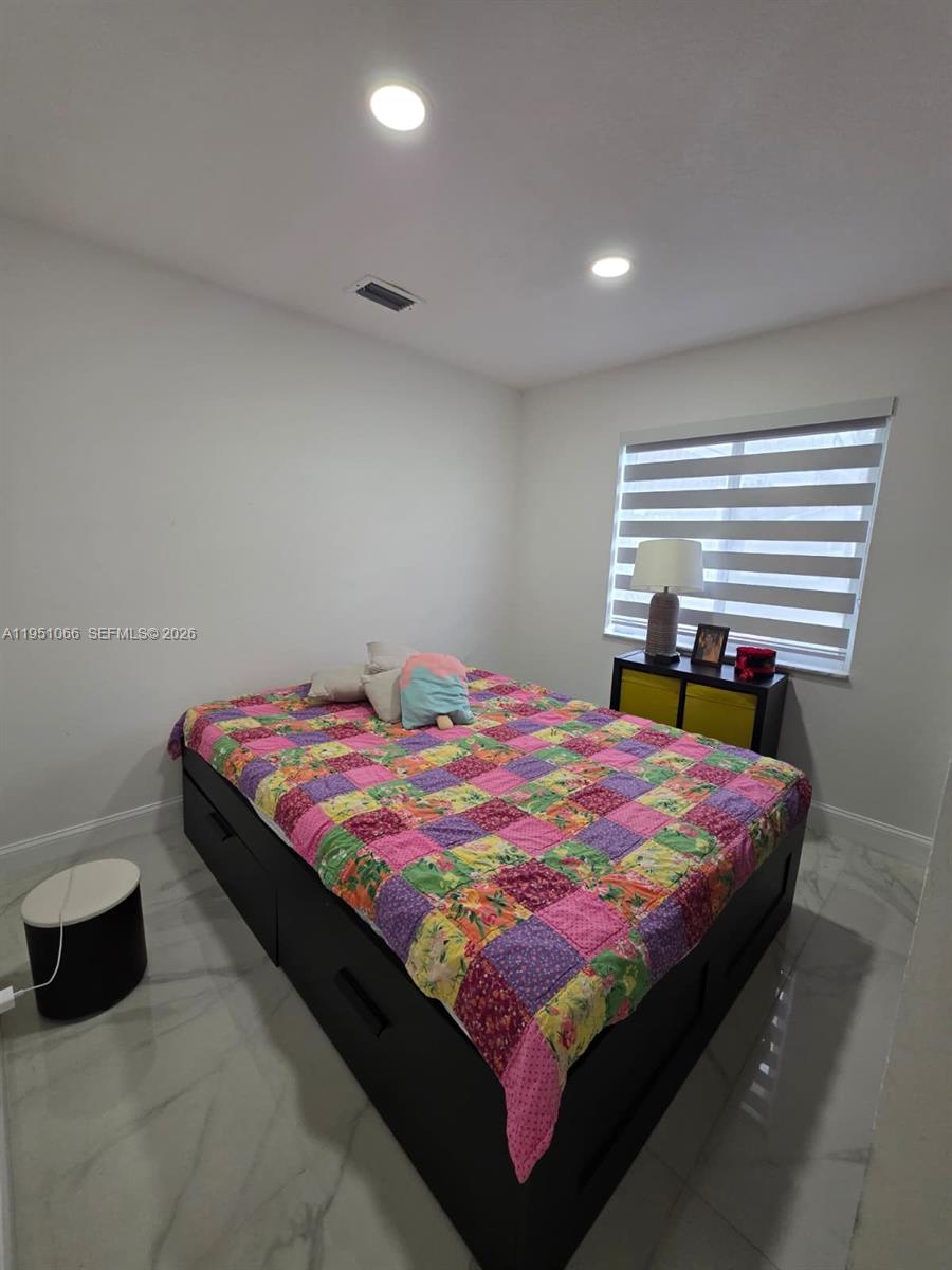 13370 Southwest 261st Terrace Homestead, FL 33032 - Photo 24 of 35 a bedroom with a bed and a lamp on dresser