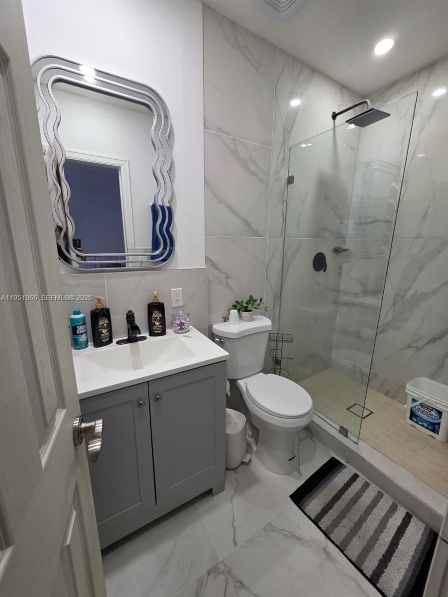 13370 Southwest 261st Terrace Homestead, FL 33032 - Photo 28 of 35 a bathroom with a toilet sink vanity granite and shower
