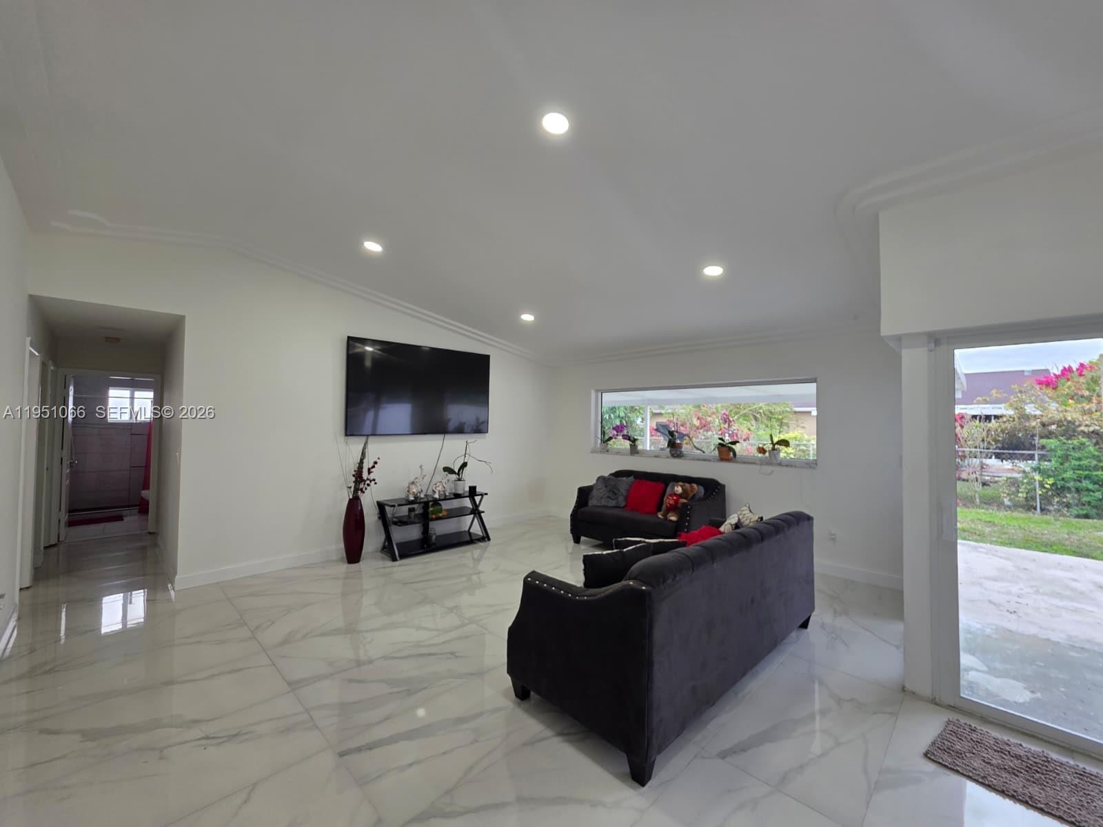 13370 Southwest 261st Terrace Homestead, FL 33032 - Photo 6 of 35 a living room with furniture and a flat screen tv