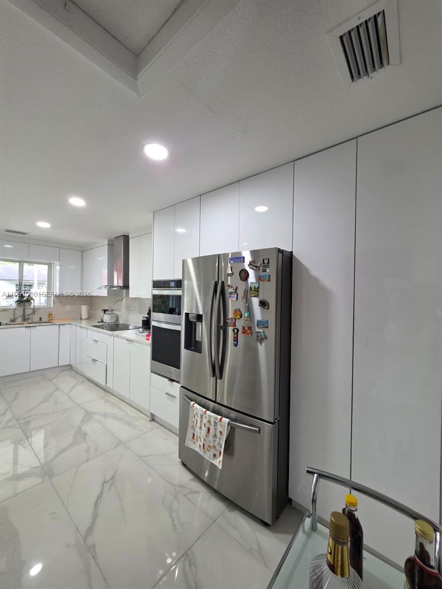 13370 Southwest 261st Terrace Homestead, FL 33032 - Photo 10 of 35 a kitchen with stainless steel appliances granite countertop a refrigerator sink and cabinets
