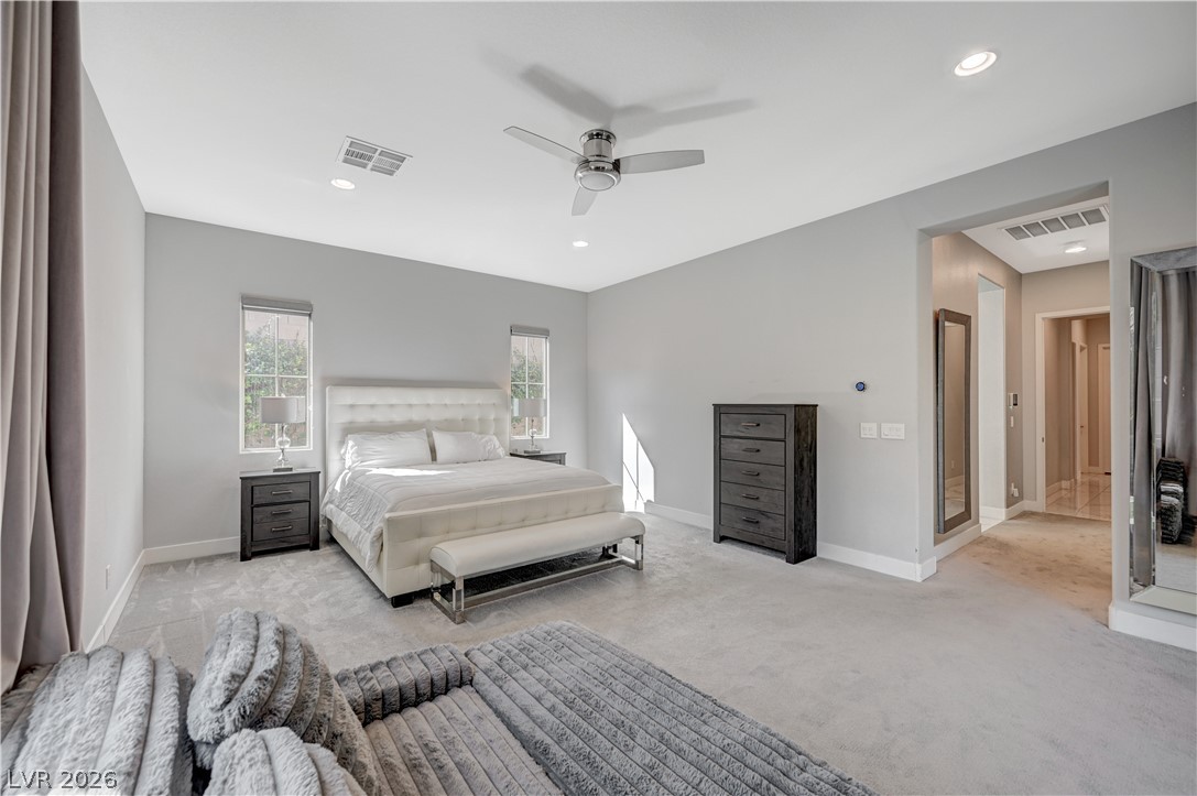 3943 Reyes Avenue Las Vegas, NV 89141 - Photo 42 of 95 Well-lit primary bedroom featuring soft carpet flooring and a ceiling fan for comfort.