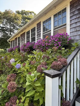 a flower garden is sitting in front of a house