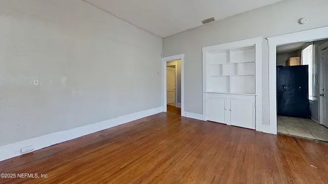 an empty room with wooden floor & closet