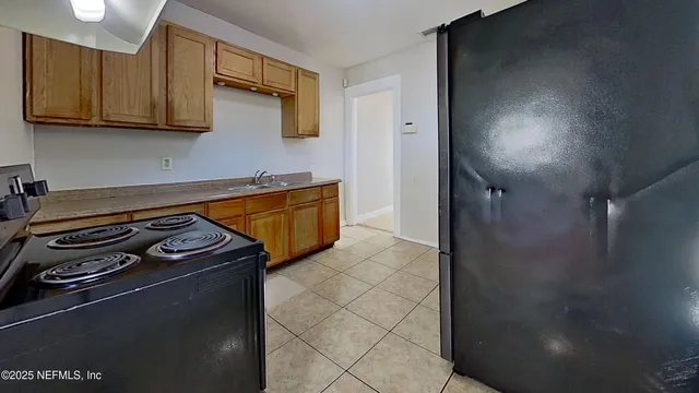 a kitchen with granite countertop a stove and a refrigerator