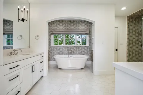 a spacious bathroom with a double vanity sink mirror and bathtub
