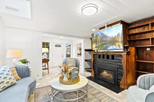 a living room with furniture a fireplace and a flat screen tv