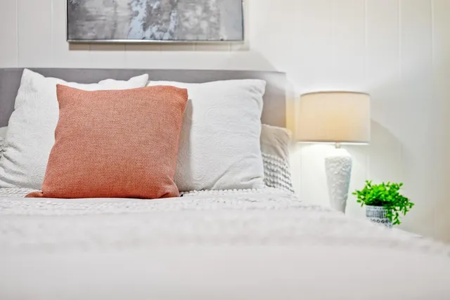 a bed sitting in a bedroom next to a small bathroom