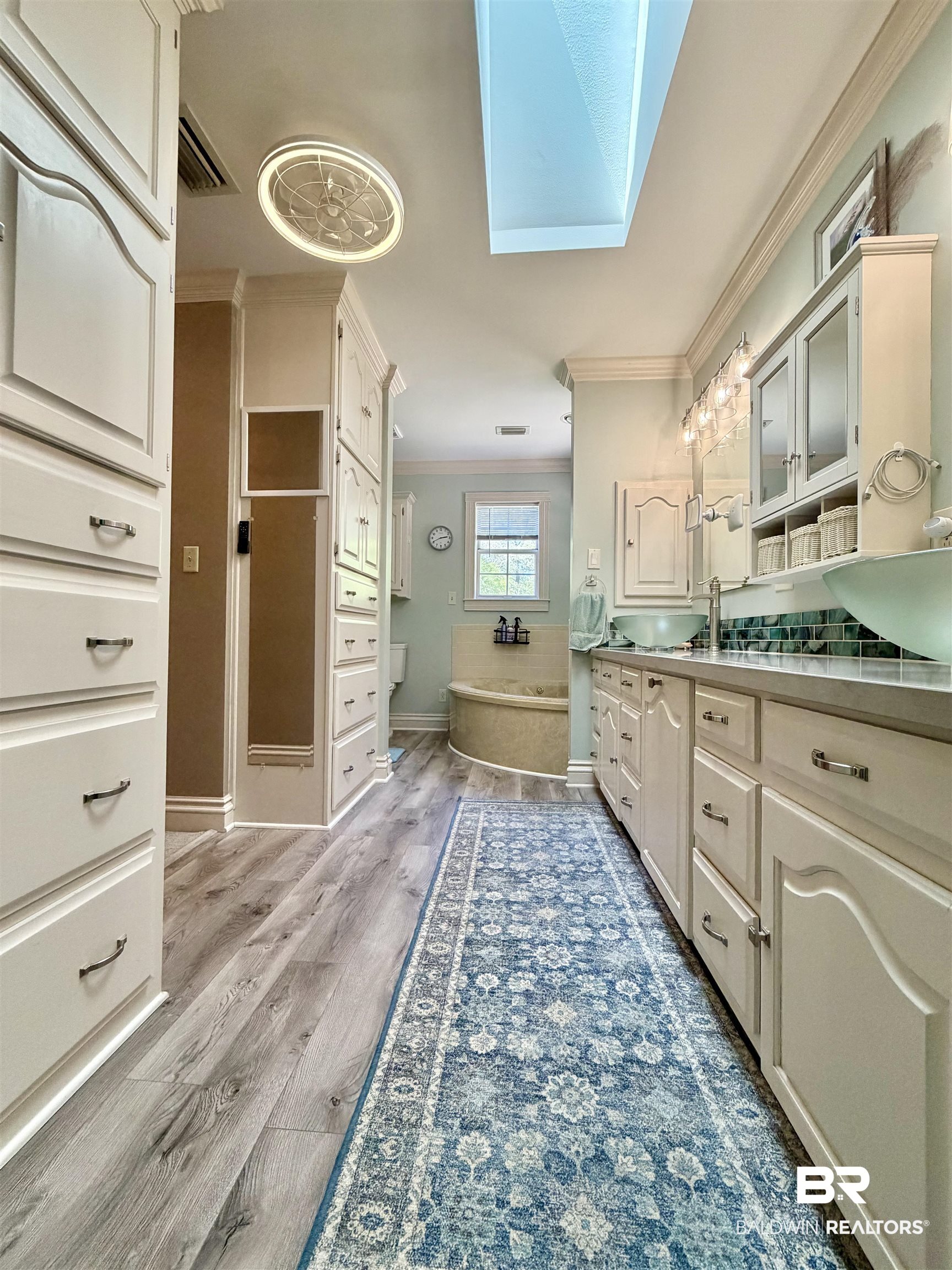 2944 Appleton Road Brewton, AL 36426 - Photo 19 of 65 Bathroom featuring ornamental molding, a skylight, vanity, a bath, and dark wood-style flooring