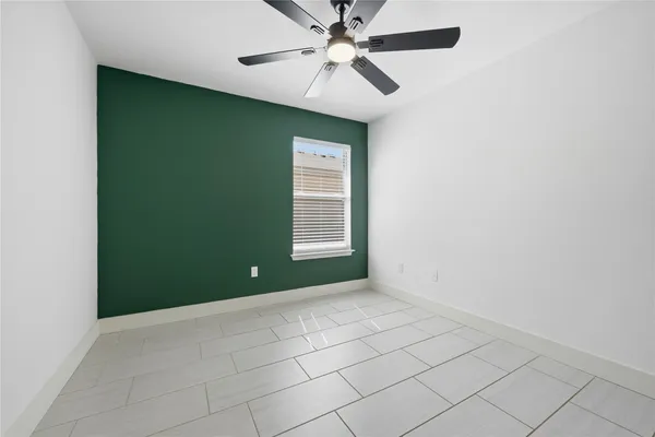 a bedroom with a bed and a ceiling fan with a dresser