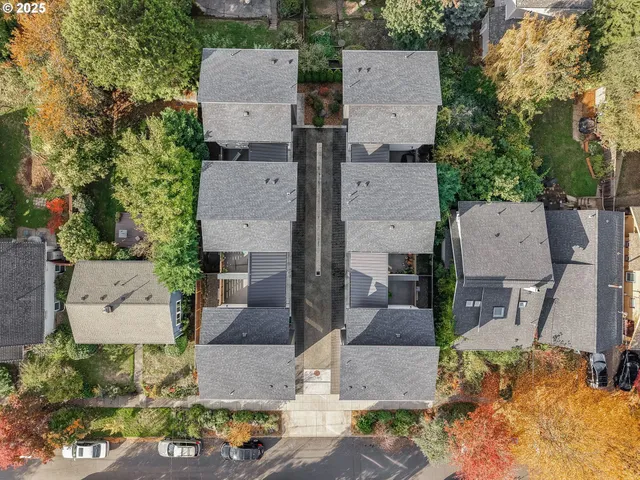 an aerial view of a residential apartment building with a yard and parking spaces