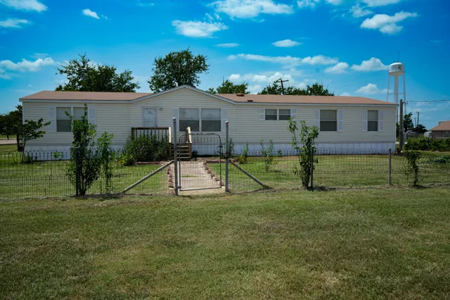 a view of a house with a backyard and a tree