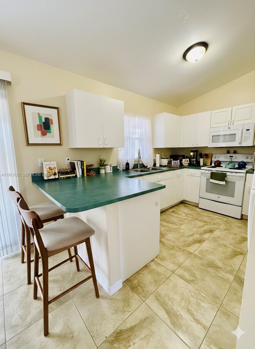 755 Arundel Circle Fort Myers, FL 33913 - Photo 6 of 22 a kitchen with stainless steel appliances granite countertop a stove a sink a microwave and a refrigerator