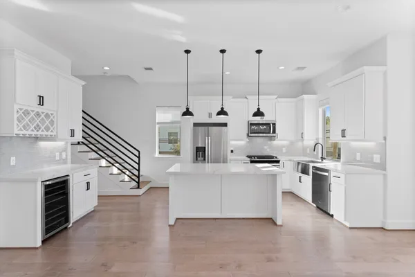 a kitchen with a sink a counter top space stainless steel appliances and a window
