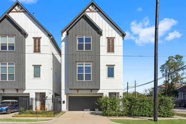 a view of a house with a small yard and wooden fence